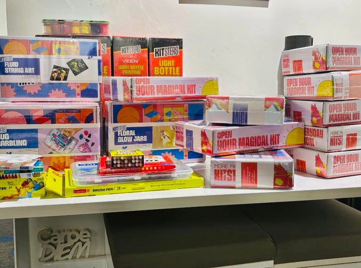 Sealed Kitsters kit boxes stacked on a shelf, ready to hand out