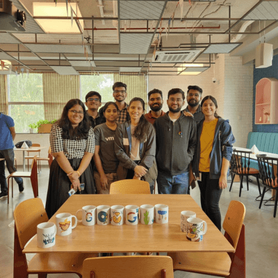 A team gathered around their hand-painted mugs after an office Kitsters workshop