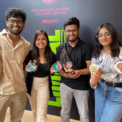 Four guests holding the pop-art coasters they painted at a brand event