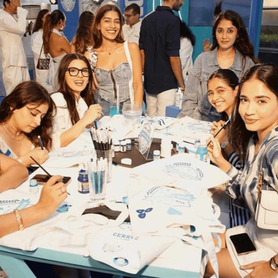 Guests painting tote bags together around a long table at a Kitsters workshop