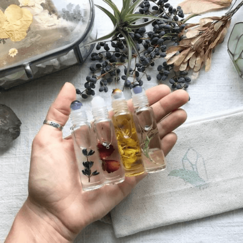 Hands holding pressed-flower resin pieces beside sprigs of dried lavender