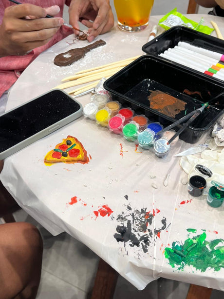 Paint pots and a half-finished piece on a Kitsters make bar table