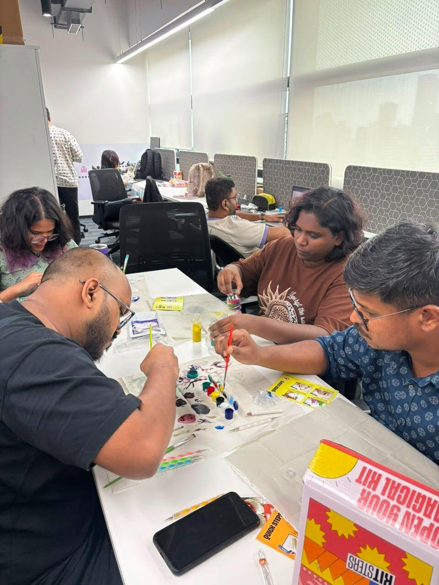 Four colleagues around a table in an open-plan office, mid-session